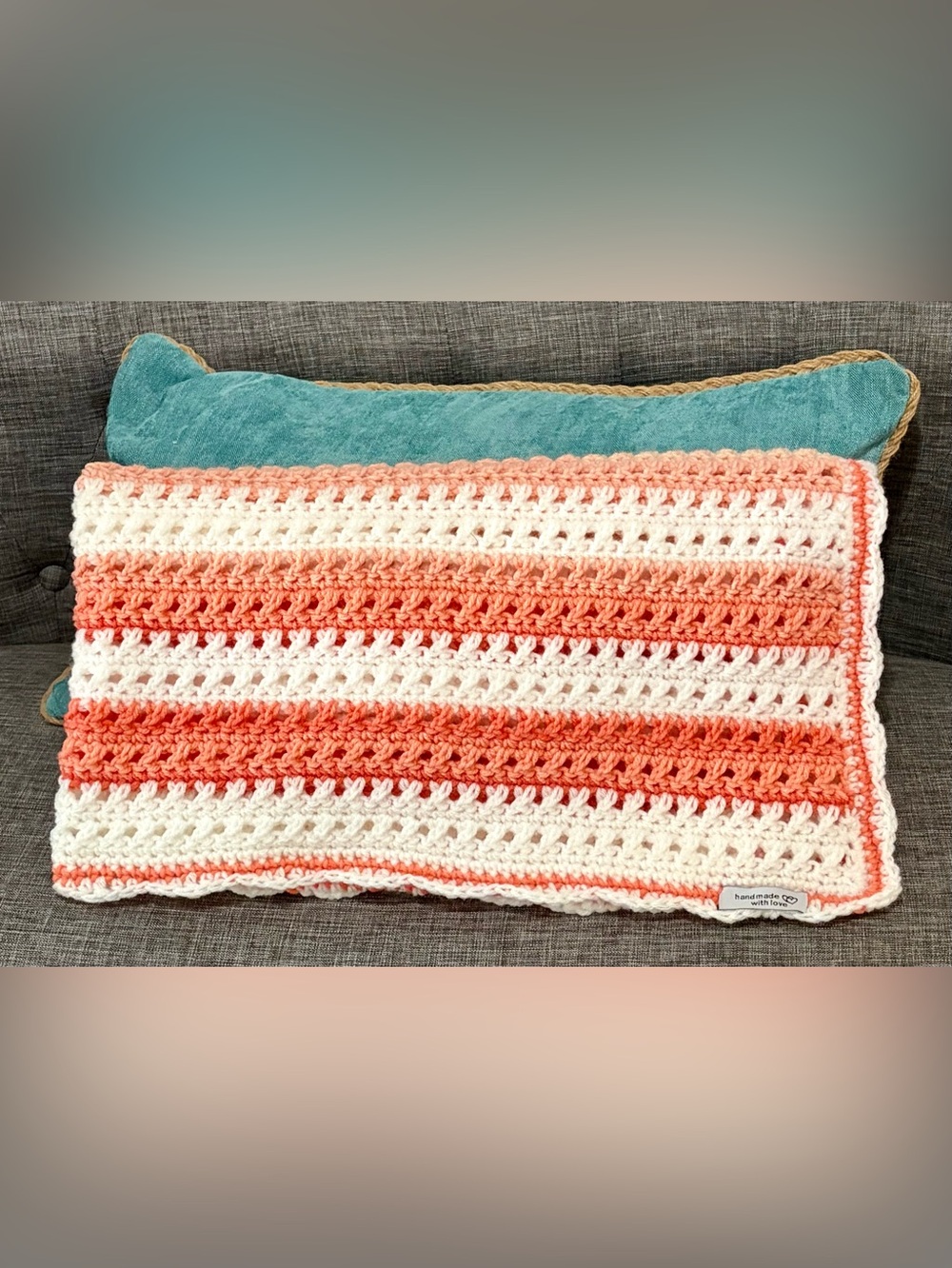 Handmade crocheted baby blanket in shades of peach and white
